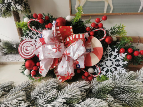 Decorative Christmas wreath with ribbons, berries, and snowflakes on a white background.