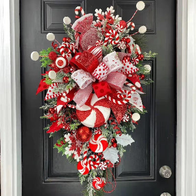 Decorative Christmas wreath with red, white, and green elements on a black door.