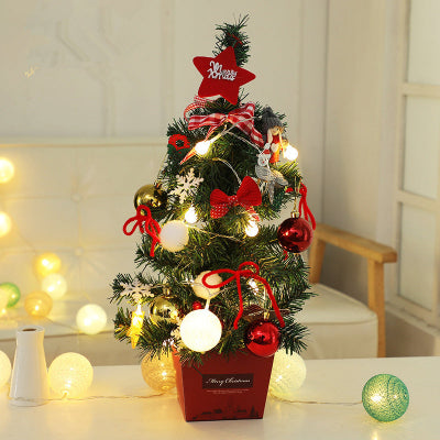 Decorated Christmas tree with red and gold ornaments on a table with a soft focus background.