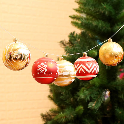 Decorative Christmas ornaments on a string with a blurred Christmas tree in the background.