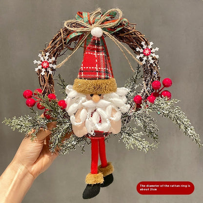 Decorative wreath with Santa Claus figure and festive decorations on a plain background