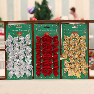 Three packages of Christmas bows in silver, red, and gold on a decorative stand.