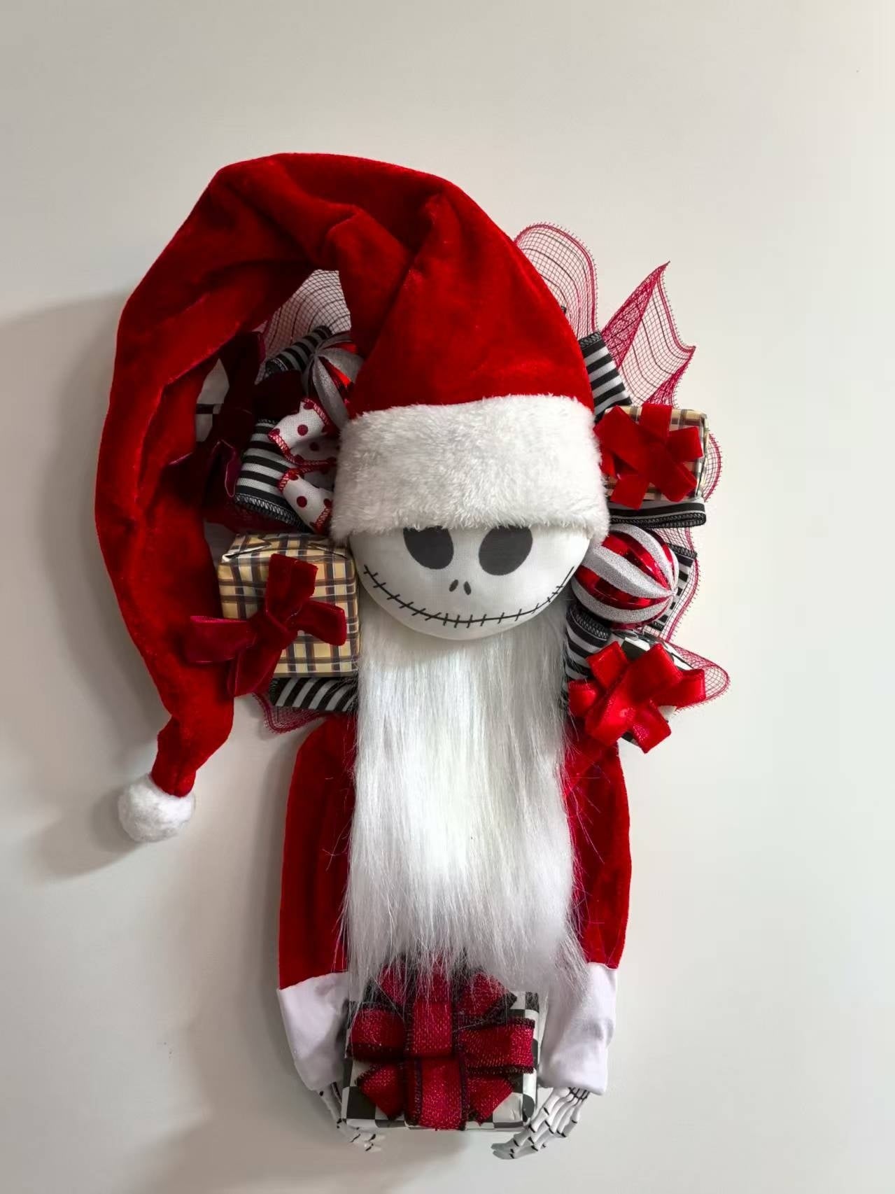 Gnome figure with a Santa hat and plaid scarf on a plain background