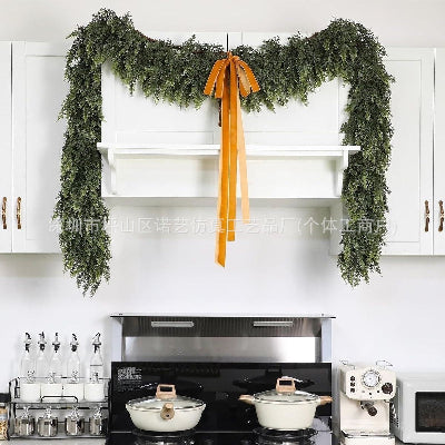 Decorative green garland with a yellow ribbon hanging above a kitchen.
