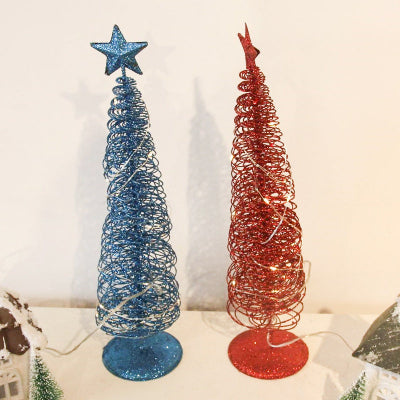 Two decorative Christmas trees, one blue and one red, on a white surface.