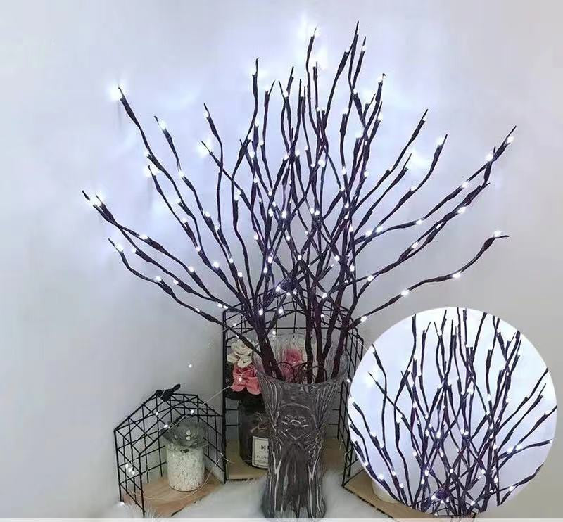 Decorative branches with LED lights in a vase on a white background