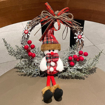 Decorative Christmas wreath with a snowman figure and red berries on a chair.