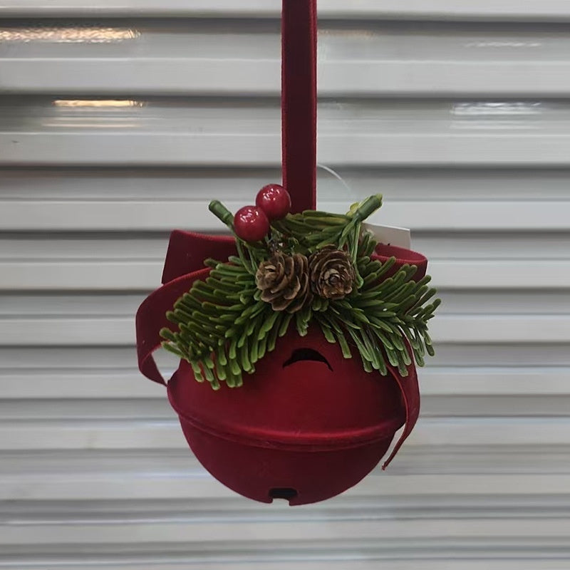 Red bird feeder with greenery and berries against a metal shutter background